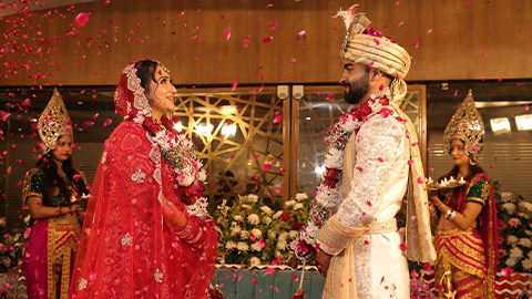 An image of Naami and Suvam on their wedding day wearing traditional wedding outfits